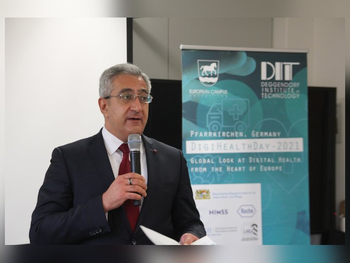 Prof. Georgi Chaltikyan addressing participants beside the conference banner