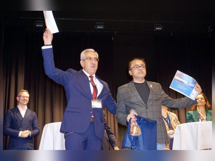 Prof. Georgi Chaltikyan is presenting conference recognition on stage