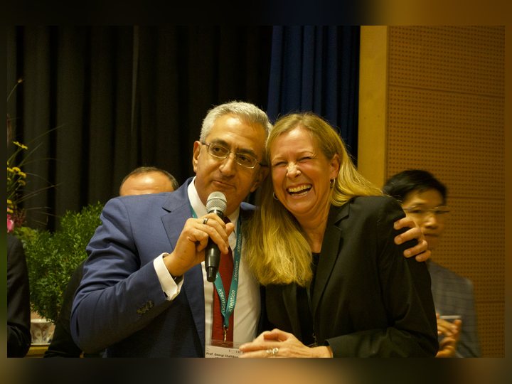 Prof. Georgi Chaltikyan is sharing a warm closing-stage moment with a colleague