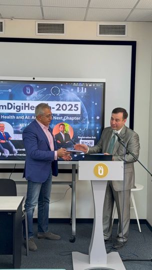 Prof. Georgi Chaltikyan presenting a recognition item to a conference participant